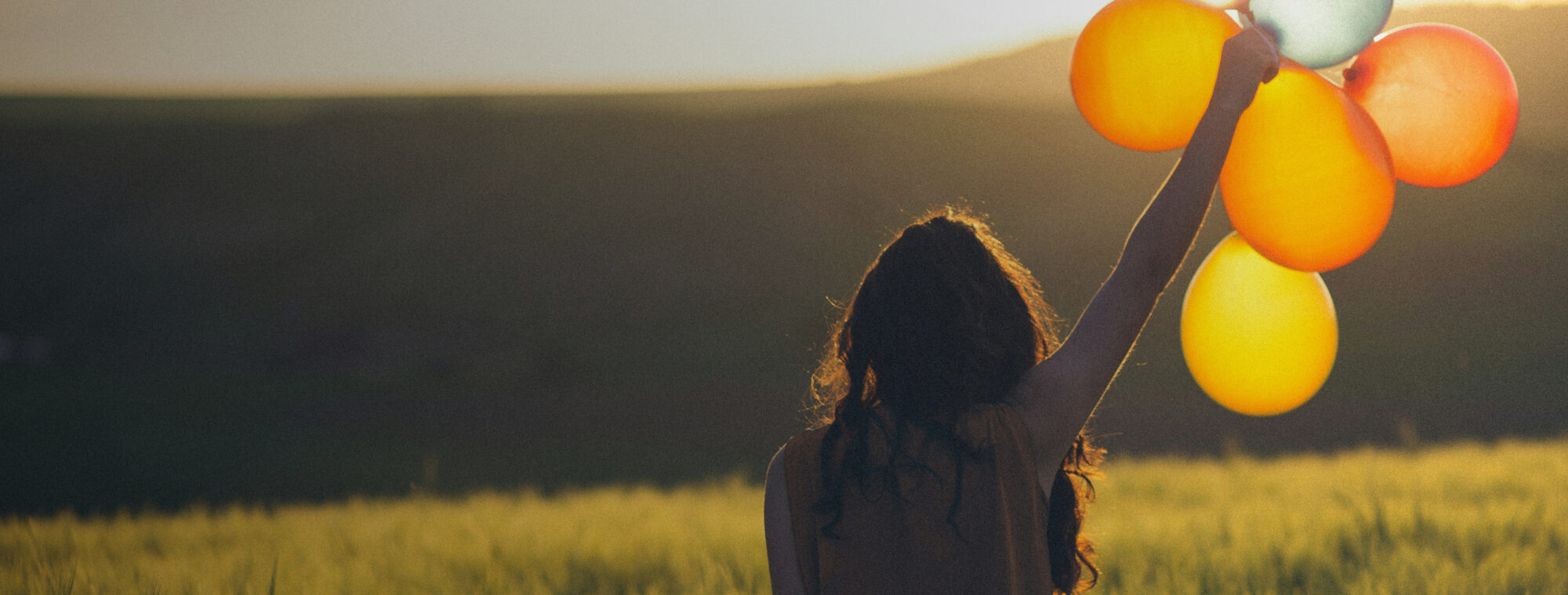 Woman holding balloons in the sunshine