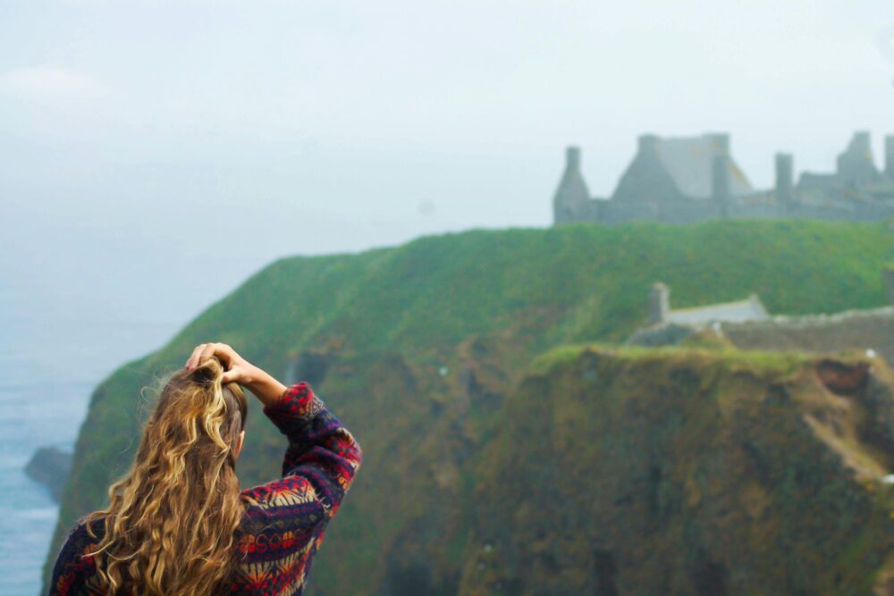 young woman looks out over cliffs