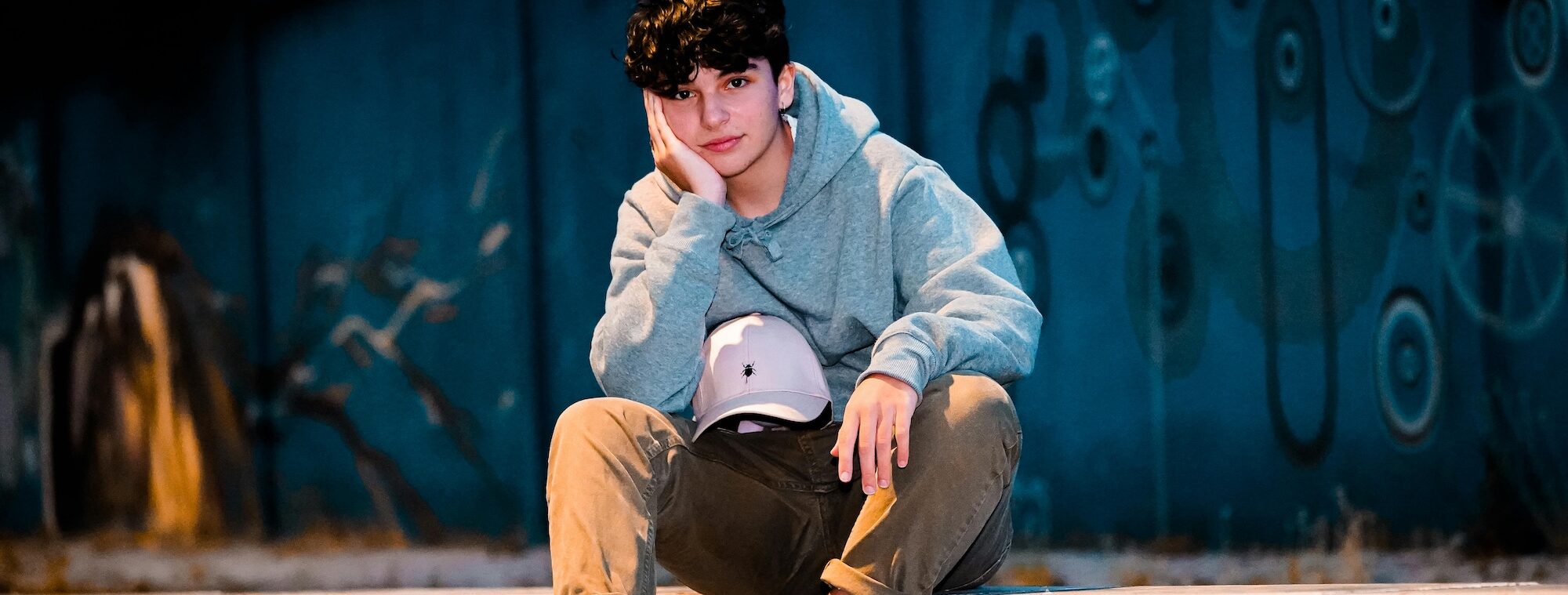 Teen boy sitting on curb