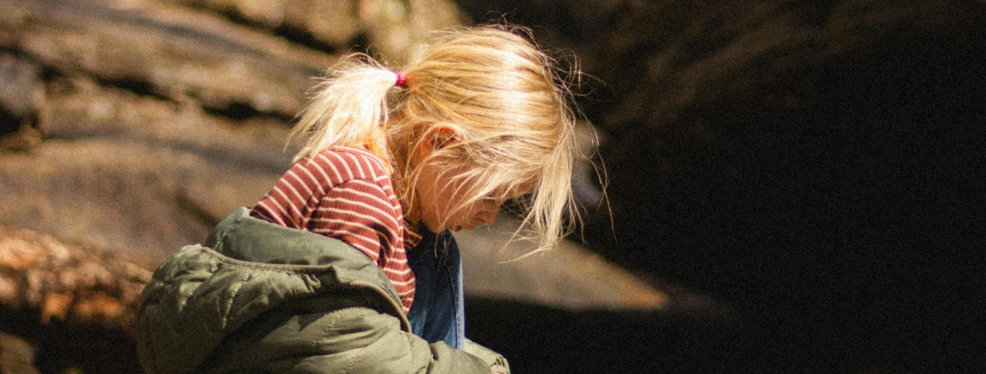 Young girl sits on a branch